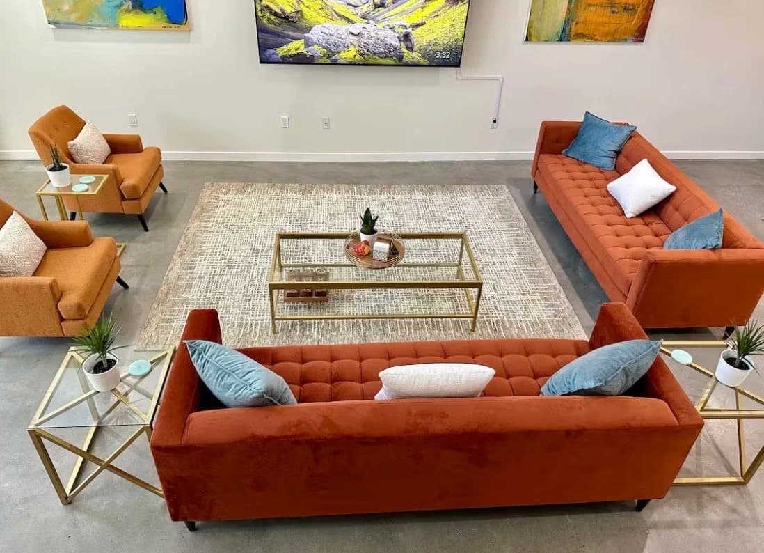 Shared resident lounge with velvet sofas and glass tables in a Santa Monica furnished rental building